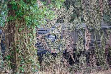a british army land rover defender wolf medium utility vehicle camouflaged and hidden amongst woodland on a military exercise, Wiltshire, UK