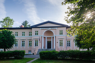 Fototapeta na wymiar Tasu - Padures manor in sunny summer evening, Kalvene, Latvia. Translated: Kalvene school