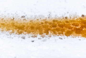 Forest ditch with yellow-brown water in snowy winter thaw day.