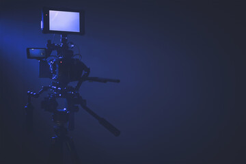 Modern Digital Cinema Camera with External Display Staying on a Tripod