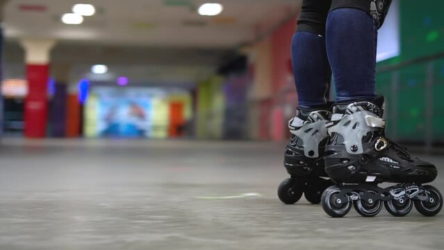 Female legs on roller skates close up, young woman skating in roller park