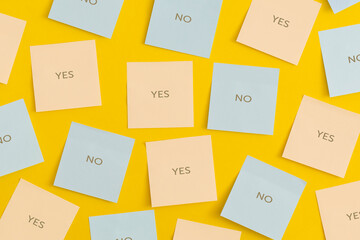 Mock up colored sticky notes on yellow background. Yes or No. Business concept, strategy, planning