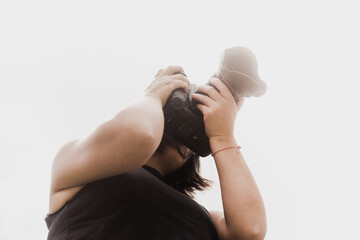 Mujer sosteniendo una cámara fotográfica y haciendo fotos
