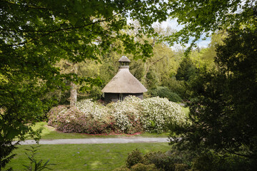Beautiful house with thatched roof. Classic style in architecture. Beautiful park with a pavilion with thatched roof in Germany 