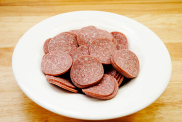 Hard Salami slices in a White bowl
