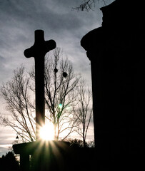Une croix à côté d'une église pendant un coucher de soleil durant l'hiver