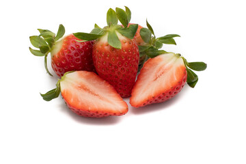 A handful of whole strawberries with their green leaves, one of them cut in half. Isolated on white background.