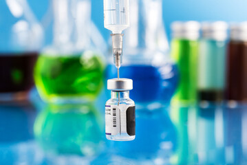 Covid-19. vaccine vial and syringe filled with vaccine. Blue background.