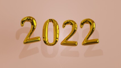 2022 gold foil balloons in front of a pink background