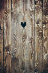 Wooden door with heart shape hole. Wood plank background. Old rustic surface