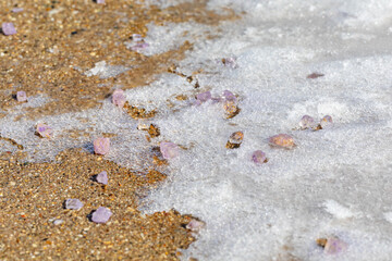 Ice melt salt melting ice and snow on sidewalk. Snow removal, melting ice and winter weather safety concept