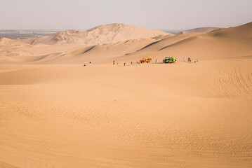 Fototapeta na wymiar Dune buggying on sand dunes in the desert at Huacachina, Ica Region, Peru, South America