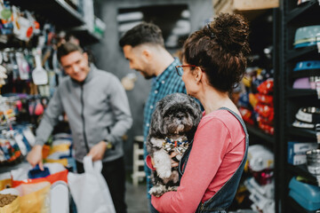 Happy couple buying food for their dog in pet shop.