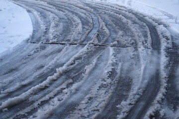 part of street in city, pavement after heavy snowfall, wet snow melts, puddles, slush and mud...