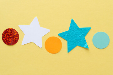 Fototapeta na wymiar simple colorful paper stars and circles on a paper surface