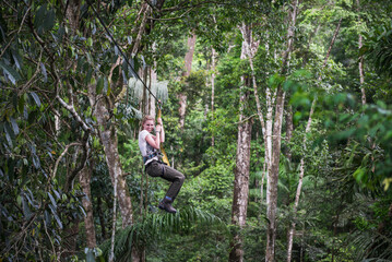 Zip lining on a zip line in Amazon Jungle of Peru on an adventure and adrenaline holiday vacation...