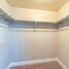 Square Small walk-in closet with shelves and metal rods below