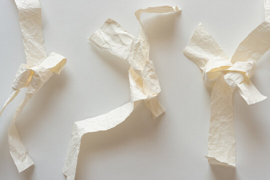 knotted crumpled paper objects on white
