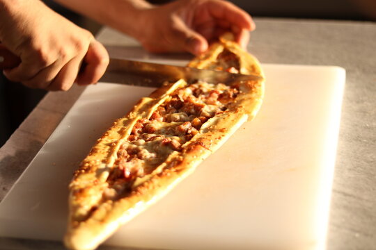 Turkish pide with vegetables cutting into pieces