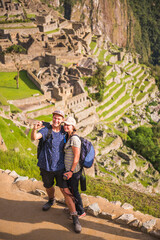 Couple taking a selfie at Machu Picchu Inca Ruins, Cusco Region, Peru, South America