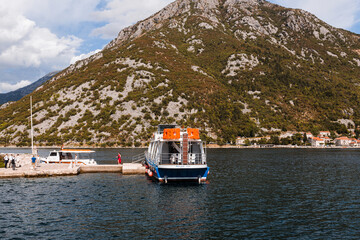 Perast, Montenegro - 15.09.2021: Tourists sailed on a yacht to the island of gospa od skrpela in the boka bay of kotor. Roman catholic church our lady of the rocks on island islet