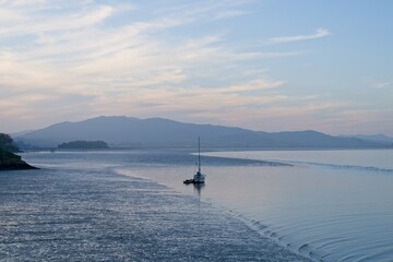 Fototapeta na wymiar Moody sunset of single boat moored in San Francisco Bay