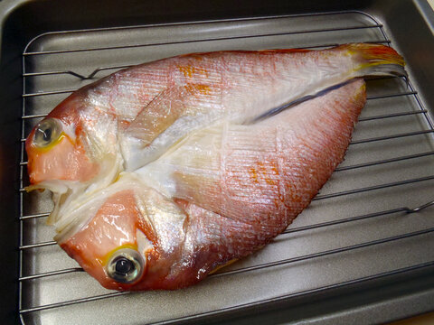Japanese dry salted fish seafood style "Himono (namaboshi)" is a way getting more umami tast. This is a picture of the cute eyed Horsehead tilefish (Amadai, Guji)  cut in half to cook. 