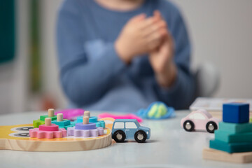 Beautiful toddler play with a wooden toys at home. Toddler play with a color educational toy. Child development. Baby hands. View from above. Detail