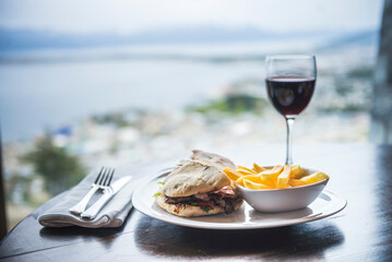 Delicious lunch with red wine at a table at a restaurant with amazing views of the Andes Mountains, Ushuaia, Tierra del Fuego, Patagonia, Argentina, South America