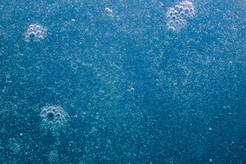 Air bubbles on deep blue background, bubbles rise to the top. Water background