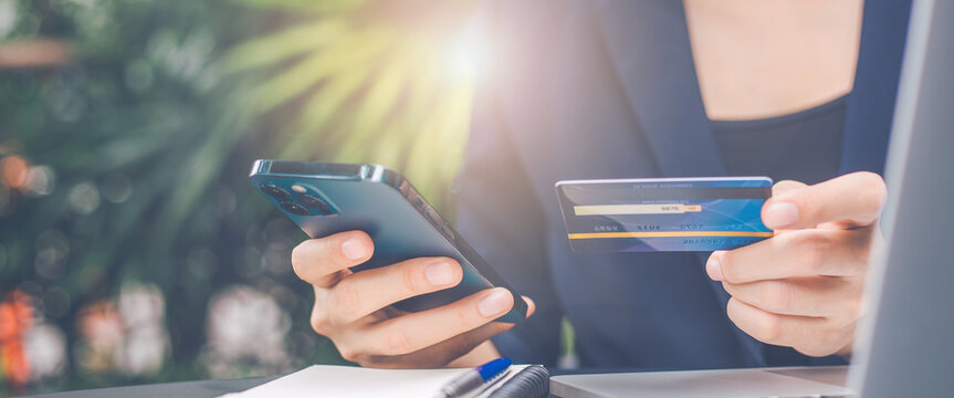 Business woman hand uses a cell phone and credit card to manage online shopping.