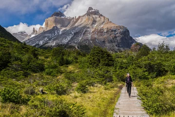 Foto op Plexiglas Cuernos del Paine Vrouw wandelen in het Nationaal Park Torres del Paine met Los Cuernos en het Paine-massief erachter, Patagonië, Chili, Zuid-Amerika