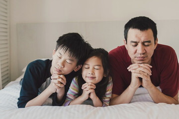 Children praying with father, family and kids fellowship worshiping online together at home,...