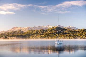 Sailing boat on misty Lake Nahuel Huapi at sunrise, Villa la Angostura, Neuquen, Patagonia,...