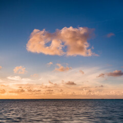 Naklejka na ściany i meble Dramatic clouds at sunset over the horizon of the Pacific Ocean, Cook Islands, background with copy space