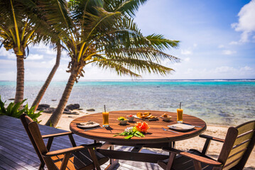 Luxury Villa accommodation with sea views of the tropical Pacific ocean and palm trees with breakfast table set up at the hotel, Muri, Rarotonga, Cook Islands