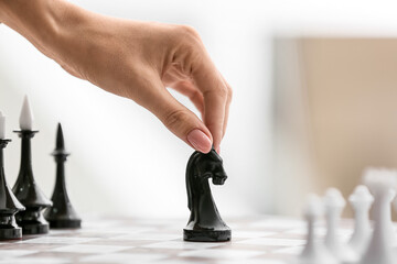 Young woman playing chess in room, closeup