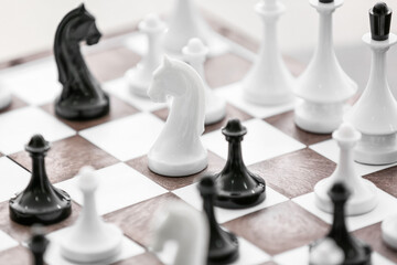 Chess pieces with game board in room, closeup