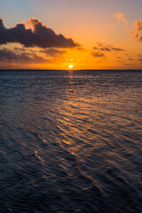 Tropical sunset background with copy space showing dramatic clouds in the sky over a horizon of the Pacific Ocean, Rarotonga, Cook Islands