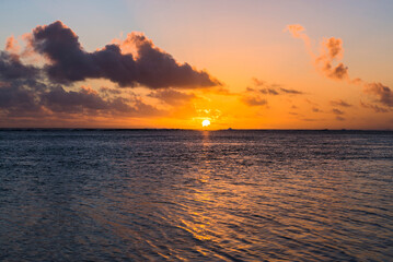 Fototapeta premium Tropical sunset background with copy space showing dramatic clouds in the sky over a horizon of the Pacific Ocean, Rarotonga, Cook Islands
