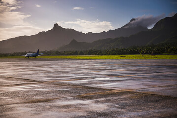 Airplane on the runway at the airport on the tropical island of Rarotonga at sunrise, Cook Islands