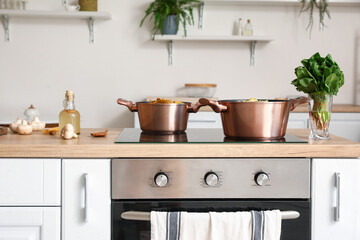 Cooking pots with prepared food on stove in kitchen