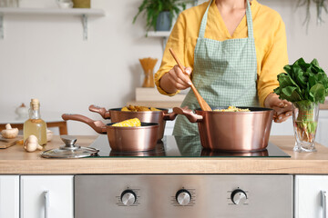Woman preparing pilaf in kitchen