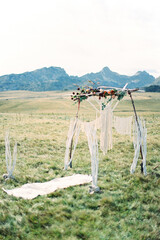 White canvas on the grass in front of a wedding arch decorated with macrame and flowers