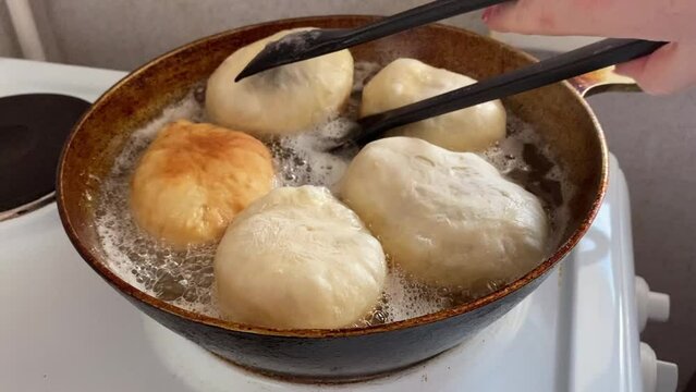 cook fries pies or belyashi stuffed with meat in a frying pan in oil 