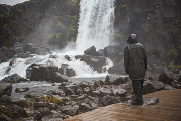 Man braving torrential rain and bad weather in Thingvellir (Pingvellir) National Park, The Golden...