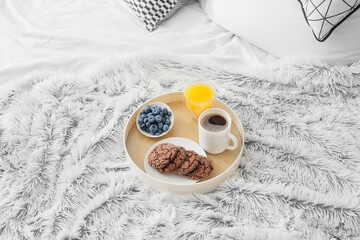 Fototapeta na wymiar Tray with delicious breakfast on fluffy plaid