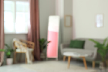 Fototapeta na wymiar Blurred view of modern living room with mirror and sofa