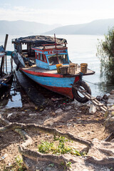 Fototapeta na wymiar Old rusty fishing boat in a village at Lake Toba (Danau Toba), North Sumatra, Indonesia, Asia