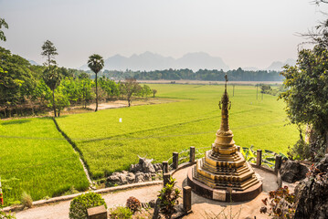 Gold stupa and rice paddy fields at Kaw Ka Thawng Caves, Hpa An, Kayin State (Karen State), Myanmar...